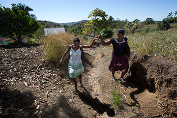 Yolande Gabriel (right) helps expectant mother Dieula Alrich make her way along a rural trail near Mizak, Haiti.