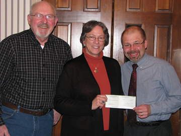 United Methodist Bishop Deborah Lieder Kiesey (center) recently traveled to Minot, N.D., to present a check for $45,000 to the Rev. Paul Krueger (right) who chairs the Hope Village board. Also shown is Bob Lower, associate director for disaster relief in Minot.