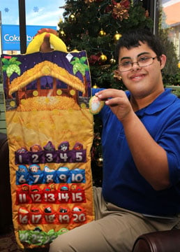 Store visitor, Andrew Donaldson, shows how to use a special holiday item offered by Cokesbury  a Fisher-Price Advent Calendar made of fabric.  Donaldson visits Cokesbury weekly through a community-based transition program.