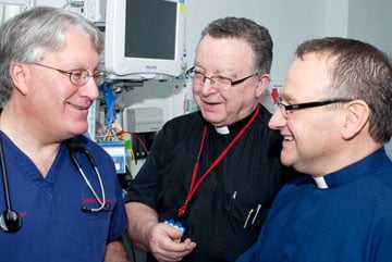 Moulton converses with the Rev. Neil Gray, Bolton's head chaplain and the Rev. Graham Culter, a British Methodist parish minister and Bolton chaplain.