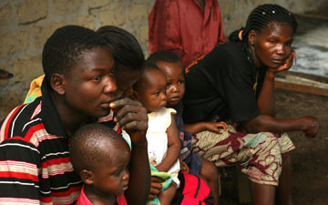 Villagers gather in a cinderblock building to hear what health community workers are doing today.