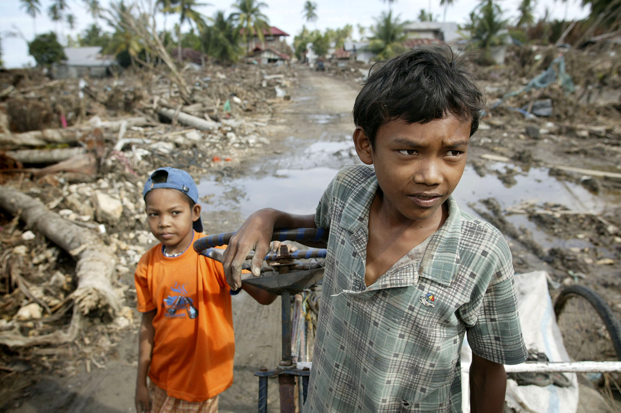 Two boys pick their way through debris-clogged streets in Banda Aceh, Indonesia. UMNS photo by Mike DuBose