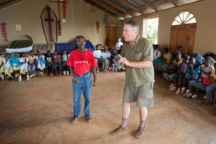 The Rev. Steve Knutsen (right), of Pleasant Valley (N.Y.) United Methodist Church, and translator Jean Claude Degazon tell a story during a vacation Bible school for children at the Methodist church in Furcy, Haiti.