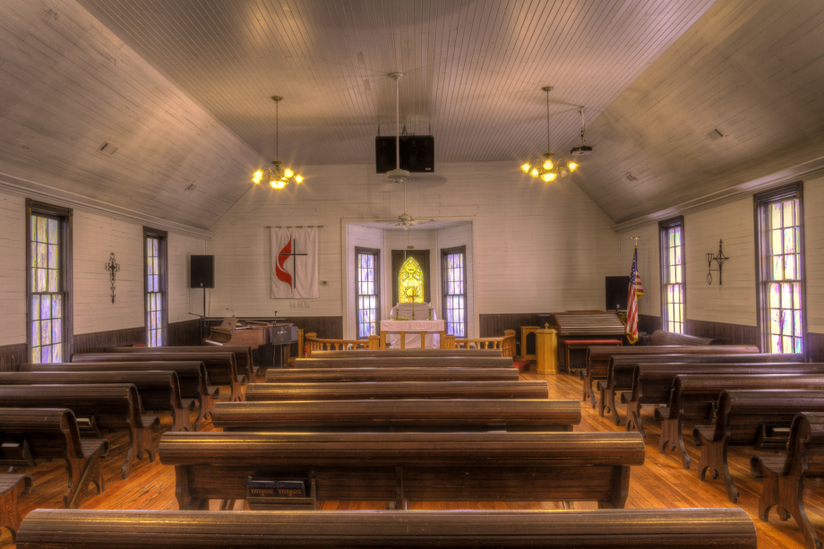 Wooden pews, heart pine floors and colored window panes are among the interior features of Field’s Chapel United Methodist Church. Photo by Scott MacInnis, courtesy Historic Rural Churches of Georgia.