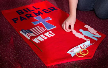 Ann Hill arranges symbols on a banner honoring Bill Farmer.