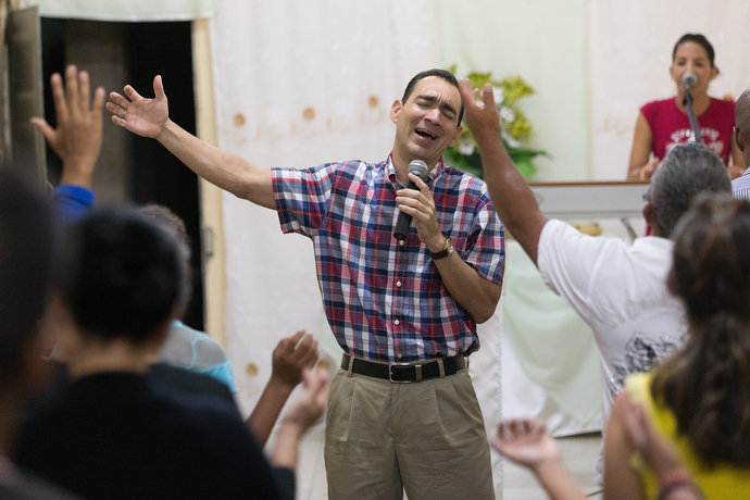 The Rev. Leandro Cordero leads a song at A Place of Hope Methodist Church in Santa Clara, Cuba. He is accompanied on the keyboard by his wife, Yenisel Ramos. Photo by Mike DuBose, UMNS.