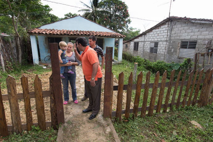 The Rev. Marcio Alcolea offers a high five to Ricardo David, son of pastor  Ricardo Rivero and his wife Ana Maria Torres, who are starting a Methodist church mission at their home. Photo by Mike DuBose, UMNS.