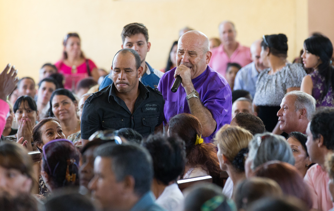 Bishop Ricardo Pereira leads people making a commitment to Christ up the aisle during worship at Marianao Methodist Church in Havana. Photo by Mike DuBose, UMNS.