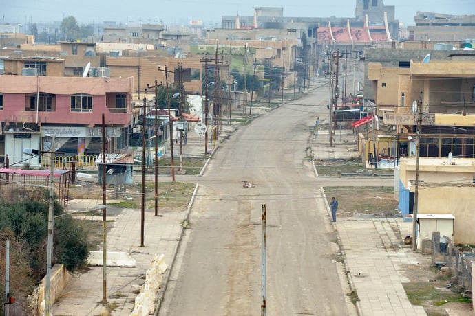 A lone member of the Nineveh Plain Protection Units, a Christian militia, keeps watch on the empty streets of the town of Qaraqosh, a Christian community that was occupied by the Islamic State in 2014 and liberated by the Iraqi army in late 2016. Residents have yet to return, citing continued insecurity. Photo © Paul Jeffrey.