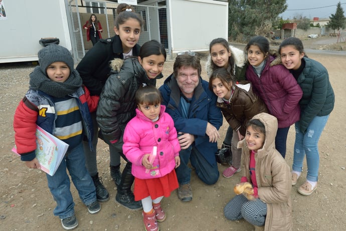 Paul Jeffrey poses with displaced children who participate in a church-run program in the Iraqi village of Bakhtme. Photo courtesy of Paul Jeffrey.