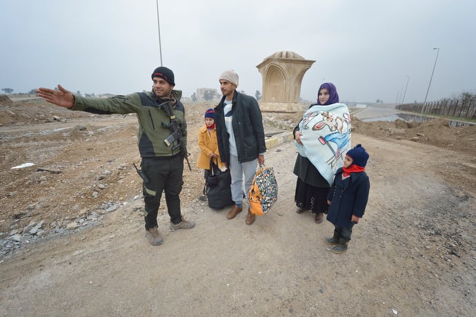 Fleeing the Islamic State, a family gets directions from an Iraqi soldier after walking into government-controlled territory in Mosul, Iraq. The Iraqi army, including elite counter-terror commandos, drove the Islamic State group out of the eastern part of the city in early in 2017. Despite the city's new freedom, Christians are unlikely to return soon due to concerns about their security in the largely Sunni Muslim community. Photo © Paul Jeffrey.