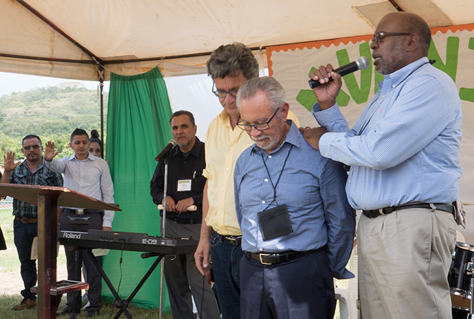 (center) Bishop Elias Galvan, director of the Honduras Mission Initiative, receives prayers and blessings from Bishop Jonathan Holston, South Carolina Area (right) and Thomas Kemper, top executive of the United Methodist Board of Global Ministries (left). The Rev. Edgar Avitia Legarda, Global Area Liaison with the Board of Global Ministries (back left), translates. Photo by Kathy L. Gilbert, UMNS.