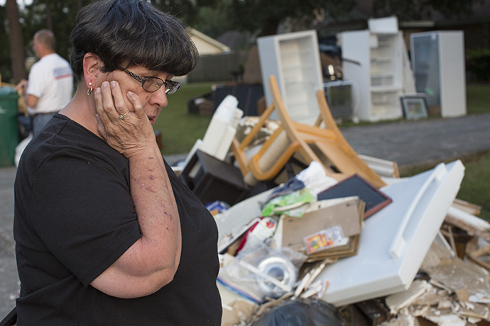 Sandy McCall looks through her furniture and flooded possessions on the street outside her home in Orange, Texas, after Hurricane Harvey. Photo by Kathleen Barry, UMNS. 