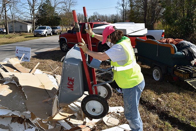 A woman uses a wheelbarrow to remove debris on a United Methodist disaster response site in South Carolina after Hurricane Matthew in 2016. Photo courtesy of the South Carolina Conference of The United Methodist Church.