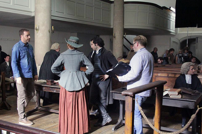 The New Room, an 18th century chapel built by John Wesley in 1739 in Bristol, England, was featured in Season 2 of the PBS period drama, “Poldark.” Pictured are actors Aidan Turner (center, in black) and Eleanor Tomlinson (to his left), who play Ross and Demelza Poldark. Photo courtesy of Mammoth Screen.