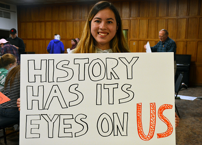 Olivia Greene, a member of National United Methodist Church in Washington, was part of an overnight “lock-in” there on March 23, the day before the Walk for Our Lives. She was working on a sign that read, “History has its eyes on us.” Photo by Erik Alsgaard.