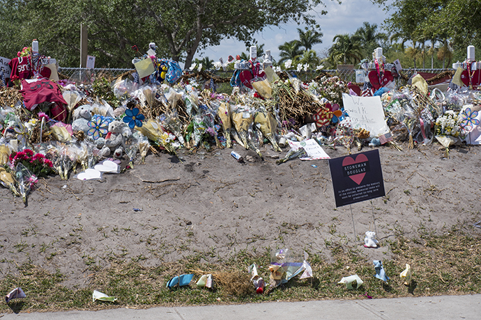 People continue to bring flowers and tributes to place outside Marjory Stoneman Douglas High School where 17 people were killed on Feb. 14. Photo by Kathy L. Gilbert, UMNS.