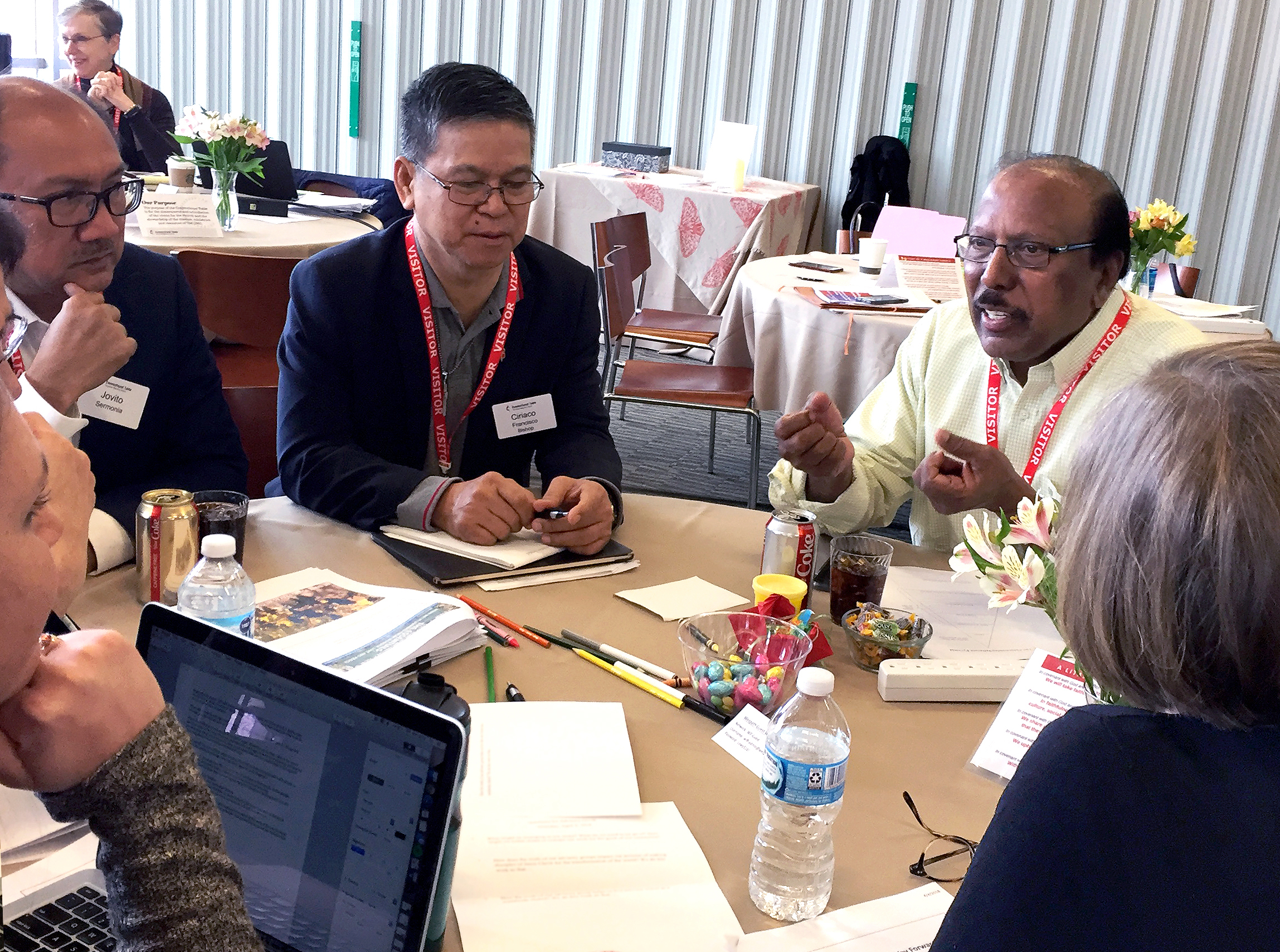 Members of The Connectional Table talk in a small group after a presentation on the Way Forward Commission. From left facing the table are members Jovito Sermonia of the Philippines, Bishop Ciriaco Francisco of the Philippines and the Rev. Jacob Dharmaraj of New York. Photo by Heather Hahn, United Methodist News Service.