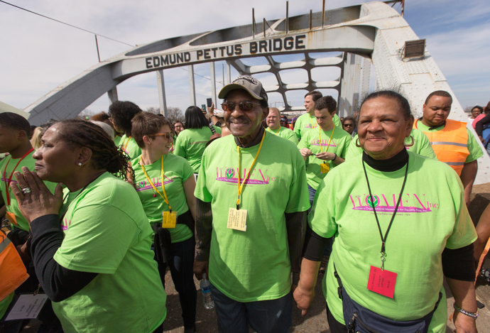 United Methodist Bishop Woodie W. White (center) crosses the Edmund Pettus Bridge in Selma, Ala., during the 50th anniversary observance of the 