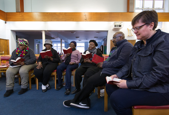 The Rev. Janet Corlett (right) takes part in a prayer and praise service at Bermondsey Central Hall Methodist Church. Photo by Mike DuBose, UMNS.