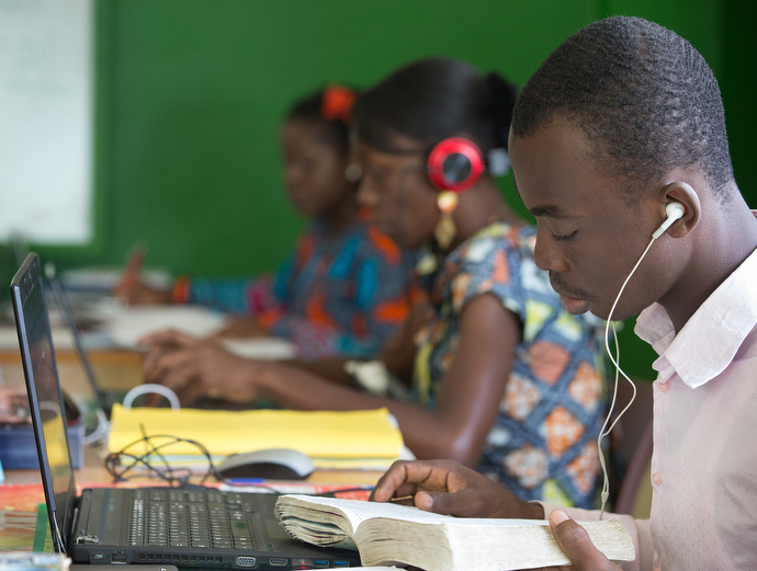 Lionel Sahuie (right) prepares a story in the newsroom at The Voice of Hope. Photo by Mike DuBose, UMNS.