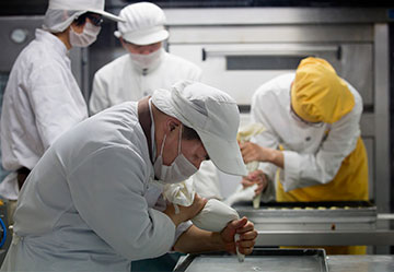 Student bakers, under the supervision of a special education teacher (wearing yellow) create pastries at the Amity Bakery in Nanjing, China.