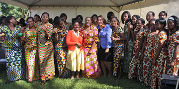 Bridget Sisney (orange sweater) and Usha Satish (periwinkle jacket), ambassadors from the Black College Fund, pose with the Africa University Choir during a break in the 20th anniversary celebration.