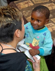 The Rev. Cynthia Fierro Harvey plays with a child at the Fairfield orphanage at the Old Mutare Mission in Zimbabwe in this 2007 file photo. A UMNS file photo by Bill Norton.