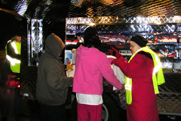 Two clients receive a meal at the Mobile  Loaves and Fishes truck, which brings free meals the first Monday of each month.