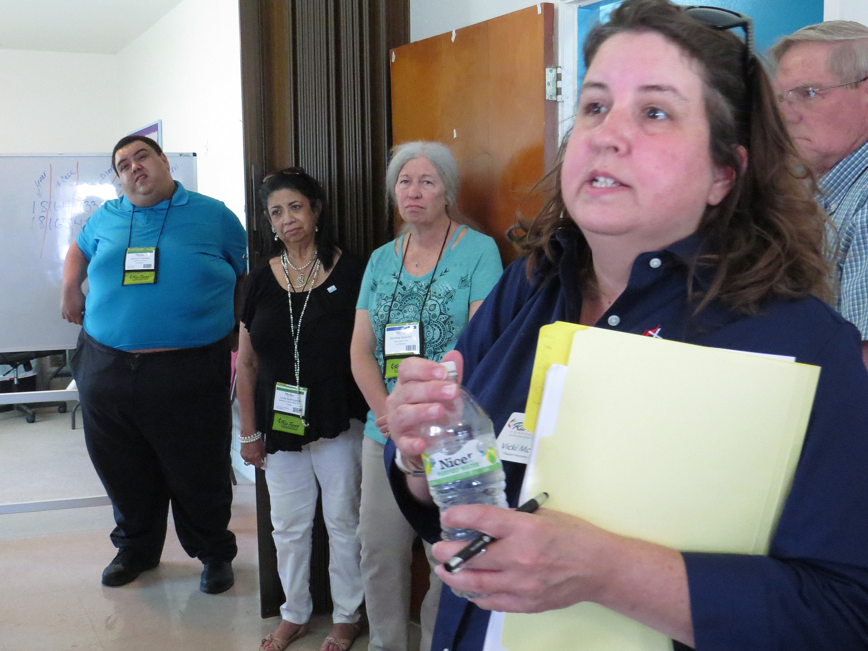 Vicki McCuistion (front), disaster recovery asset manager for the Rio Texas Conference, gives a briefing during a Hurricane Harvey recovery tour stop at Aransas Pass United Methodist Church. The conference put on the tour during its annual gathering, hoping to persuade delegates to share the word with their churches that volunteer teams are still needed for recovery work. Photo by Sam Hodges, UMNS.