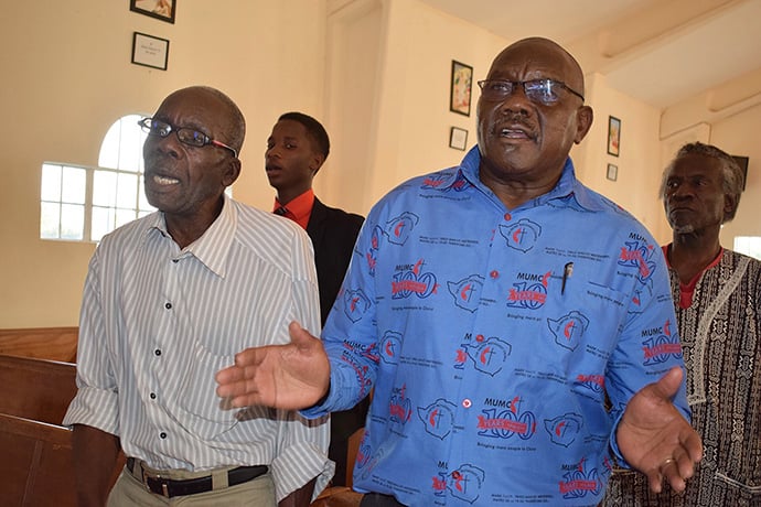 United Methodists Washington Gurure (left) and Stephen Gurupira join in singing during a prayer service for peace in Zimbabwe at St. Mary’s Anglican Church. Photo by Eveline Chikwanah, UMNS.