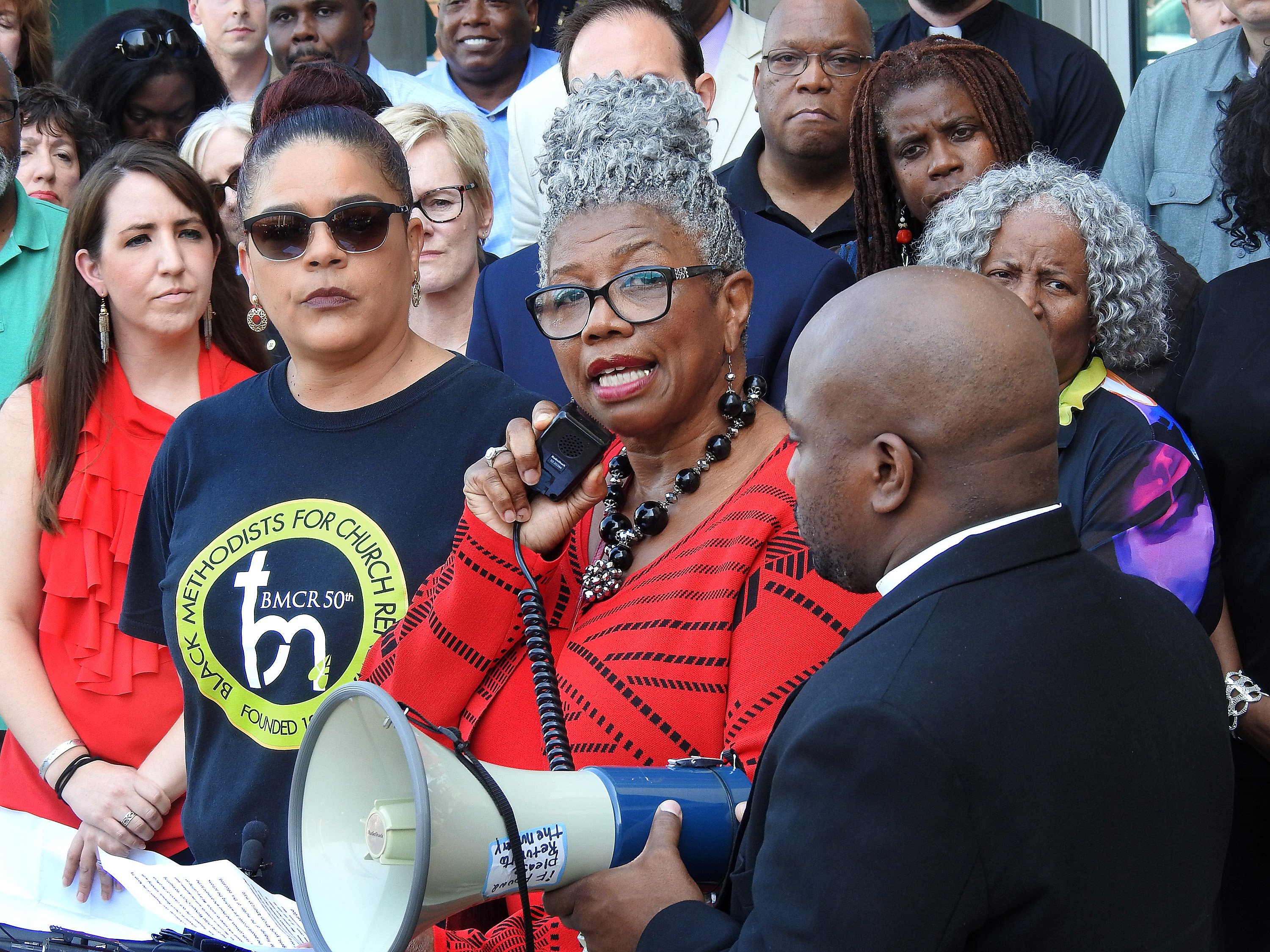 The Rev. Ouida Lee (speaking) draws a strong response from United Methodists gathered outside Dallas police headquarters.  A diverse group of North Texas Conference clergy spoke and marched, demanding justice for Botham Jean, a 26-year-old black man killed in his Dallas apartment by a white police officer. Photo by Sam Hodges, UMNS.