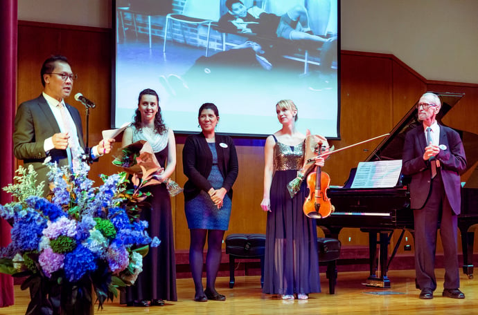 The Rev. Liberato “Levi” Bautista (left), United Methodist Board of Church and Society; Yamile Eusebio (middle), Global Foundation for Democracy and Development; and Cyril Ritchie (right), Union of International Associations, make a post-concert presentation to musicians Anna Petrova (second from left) and Molly Carr (second from right). Bautista, Eusebio and Ritchie are board members of the Conference of Non-Governmental Organizations in Consultative Relationship with the United Nations. Photo by Ramon Leonardo Cabrera/GFDD.