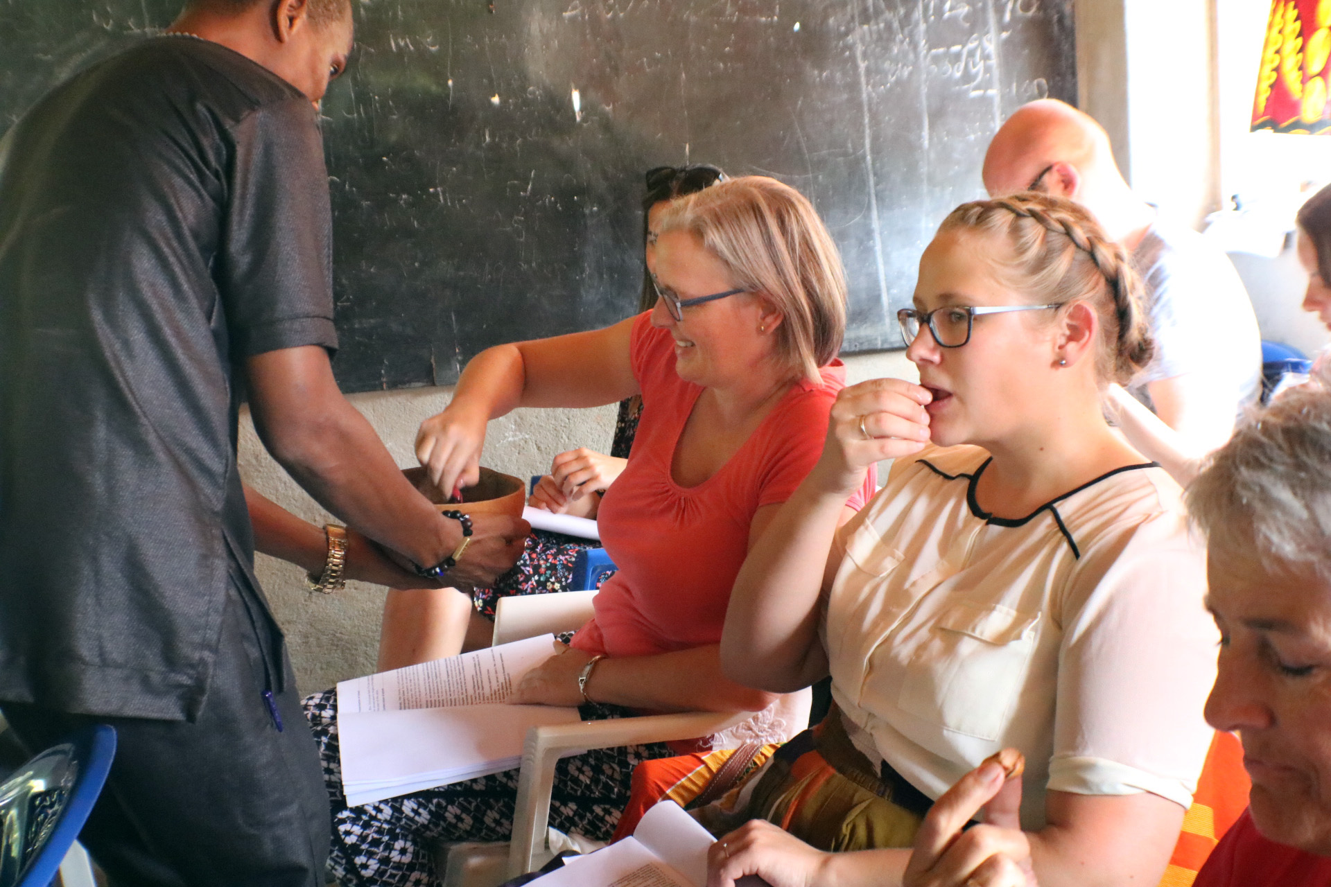 Members of the Mosaic Gospel Choir of Norway sample traditional African Kola nuts during the dedication of a new public school funded by Mission Alliance, part of the Church of Norway. Photo by E Julu Swen, UMNS.