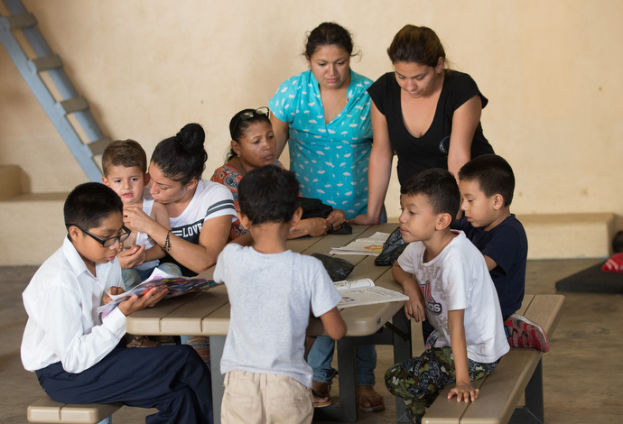 Mothers and children gather around a table in the playroom at the "Door of Hope" Salvation Army shelter in Tijuana. Photo by Mike DuBose, UMNS.