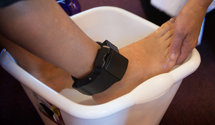 A migrant from Central America, wearing a tracking device on her ankle while she pursues an asylum claim in the U.S., has her feet washed during worship at Exodus United Methodist Church in San Diego. Photo by Mike DuBose, UMNS.