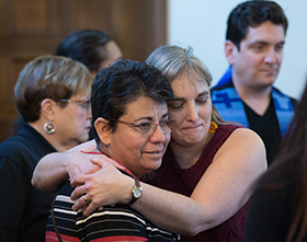 The Rev. Patricia Gandarilla (front, left) of El Buen Pastor United Methodist Church in Detroit and Lori Valentine de Segovia of the Virginia Conference embrace during a migration-themed worship service at Exodus United Methodist Church in San Diego. Photo by Mike DuBose, UMNS.