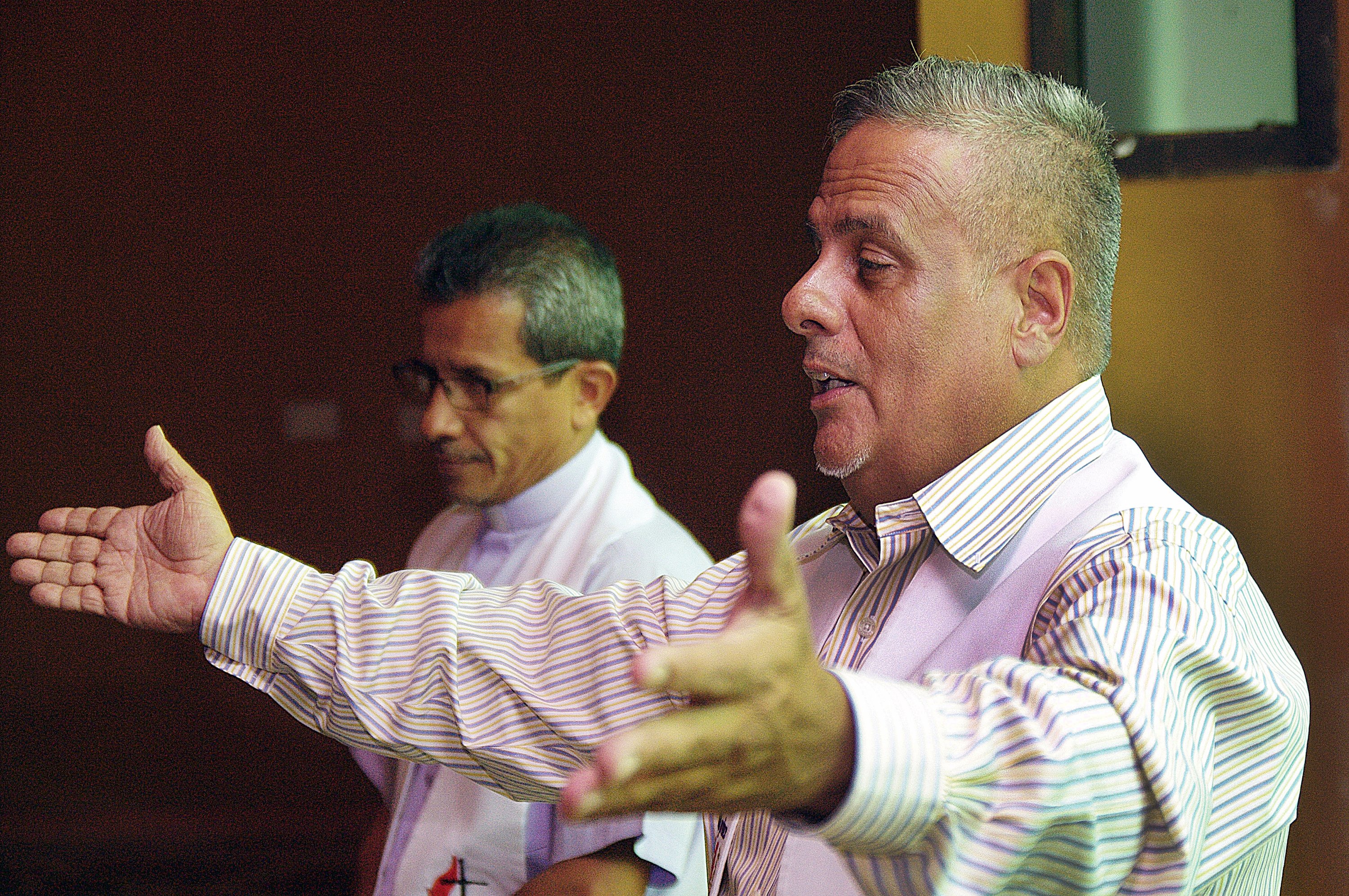 Pastor Fernando Mendez, Christian Methodist Community of Venezuela, right, and Bishop Toby Ramirez, Council of Evangelical Methodist Churches of Venezuela, presided together during the sacrament of communion, which served as a symbol of the spirit of unity that reigned during a dialogue about establishing a national Methodist church presence in Venezuela. Photo by Gustavo Vasquez, UMNS.