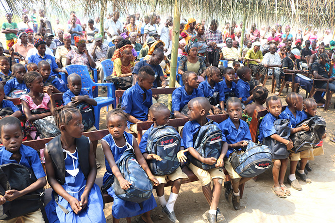 Future students at The United Methodist Church Primary School in Sayllu, Sierra Leone, listen to speakers from the Sierra Leone Conference’s Community Empowerment for Livelihoods and Development. The group provided the children with school supplies. Photo by Phileas Jusu, UMNS. 