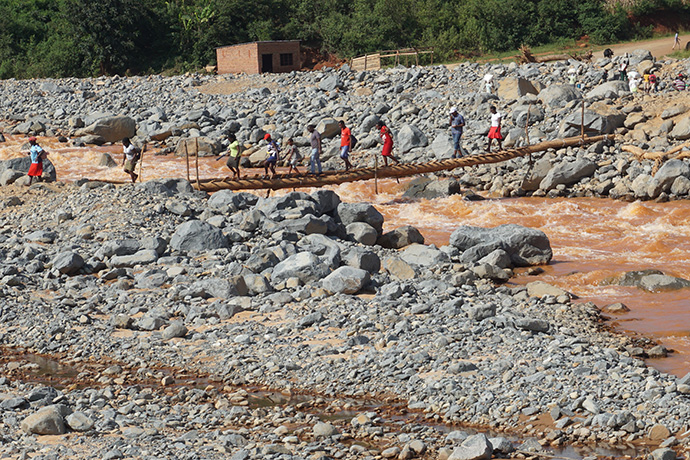 People cross a makeshift bridge above the Nyahode River in Kopa Township, Zimbabwe. The area is among those affected by Cyclone Idai, which left hundreds dead and many more missing in Zimbabwe, Mozambique and Malawi. Photo by Kudzai Chingwe, UMNS.