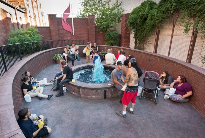 Community members gather for a weekly meal and prayer support in the courtyard at Johnson Memorial United Methodist Church in Huntington, W.Va. Photo by Mike DuBose, UMNS.