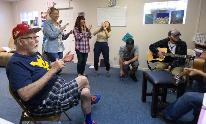 Bob Jones (left) claps along with the Voices of Hope choir at Friendship House, a mental health drop-in center in Morgantown, W.Va. Jones, a former member of Spruce Street United Methodist Church, is part of a group from the church that visits regularly with clients at Friendship House and the associated needle exchange clinic. He has recently become a regular member of the choir. Photo by Mike DuBose, UMNS.