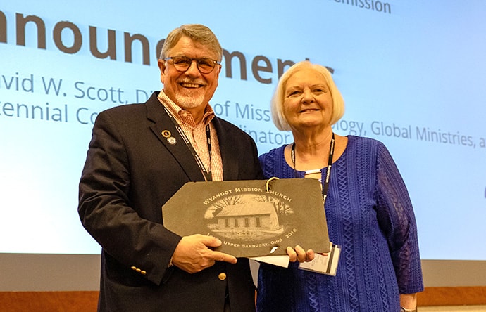 Chief Janith English, right, Principal Chief of the Wyandot Nation of Kansas, displayed a slate from a previous roof of the church named after John Stewart, the first Methodist missionary in the U.S., to the Rev. Alfred Day and others at the bicentennial conference. Photo by Jennifer Silver, Global Ministries.