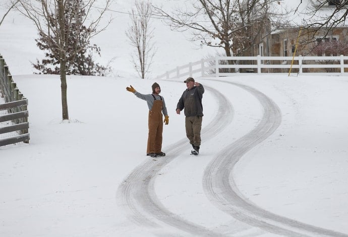 Jim (left), a resident at Jacob's Ladder, checks in with Mark Utterback, director of farming. Residents help with livestock, bale hay, collect firewood and maintain machinery during their six-month stay. Photo by Mike DuBose, UMNS.