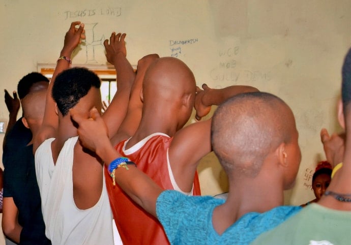 A group of boys at Kingtom Remand Home act out a skit titled "We Are the World." The performance was part of a Day of the African Child celebration sponsored by the Sierra Leone Conference prison ministry. The remand home does not permit photos that show the faces of detainees. Photo by Saidu Samura, Sierra Leone Correctional Services.