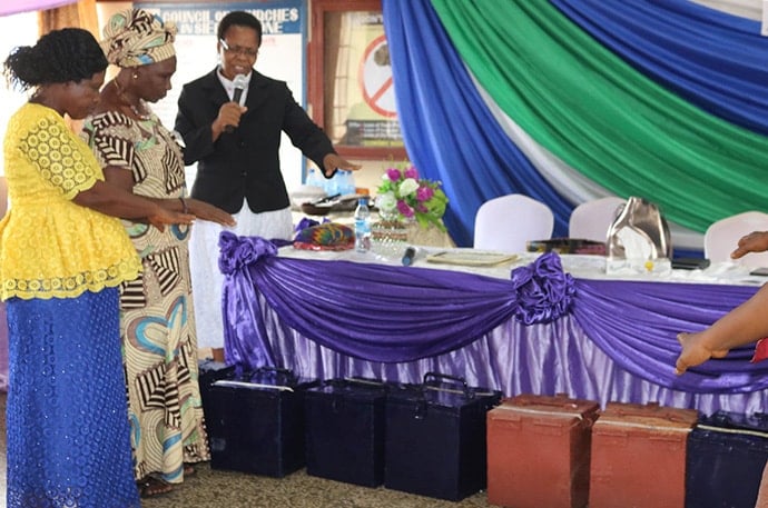 The Rev. Natalia Manyeza blesses loan lock boxes Sept. 6 at the end of a four-day women’s empowerment training in Freetown, Sierra Leone. Photo by Phileas Jusu, UM News.