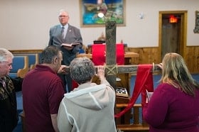  The Rev. Earl Bible invites parishioners to the cross during the Good Friday service at Whitmer United Methodist Church in Seneca Rocks, W.Va. Photo by Mike DuBose, UM News.