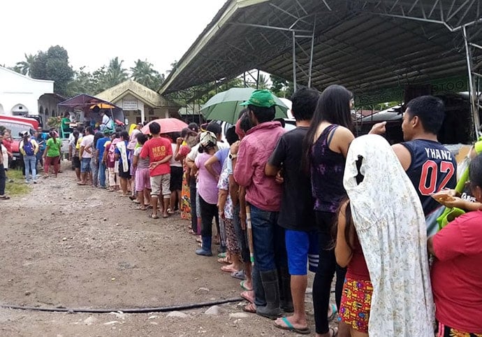 Earthquake survivors line up to receive supplies from the Ka-Tambayayong response team, a collaboration among the Mindanao Central East District led by the Rev. Recto Baguio, Greene Academy and Southern Philippines Methodist College, Inc., in Makilala, North Cotabato, Philippines. Photo courtesy of Rhea Jane Mella Donisa.