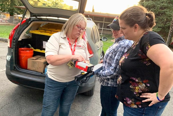 California-Nevada Conference Disaster Response Coordinator Sonja Edd-Bennett (left) shows Revs. Jacey and Emily Pickens-Jones (right), pastors of Sonoma United Methodist Church, features of USB chargers from the conference being donated to the church's hospitality enter. Photo by Lucy Nelson, courtesy of California-Nevada Conference.