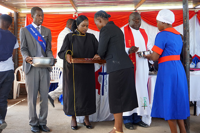 Bhero Munashe (left), Pastor in Charge Edith Madora and the Rev. Oscar Nyasha Mukahanana serve Holy Communion at Maximum Salvation United Methodist Church in Manresa, Zimbabwe. Bishop Eben K. Nhiwatiwa granted the prison church circuit status in 2019. Photo by Kudzai Chingwe, UM News. 